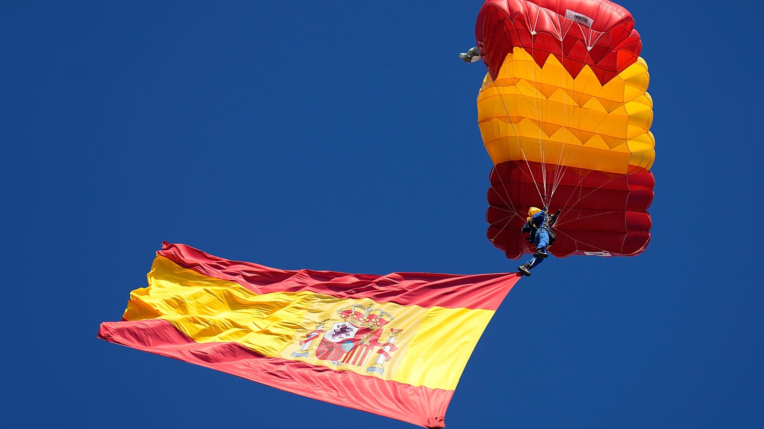 Un paracaidista de las Fuerzas Armadas españolas porta la bandera española durante el desfile militar del Día de la Hispanidad en Madrid, España, el 12 de octubre de 2026.