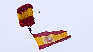 A paratrooper from the Spanish Armed Forces carries a Spanish flag during a military parade on 12 October 2025.