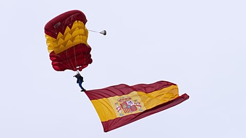 A paratrooper from the Spanish Armed Forces carries a Spanish flag during a military parade on 12 October 2025.