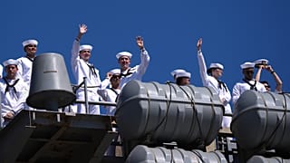 Sailors wave aboard the USS Abraham Lincoln aircraft carrier as it returns to Naval Air Station North Island after deployment Thursday, Oct. 8, 2026, in Coronado, Calif.