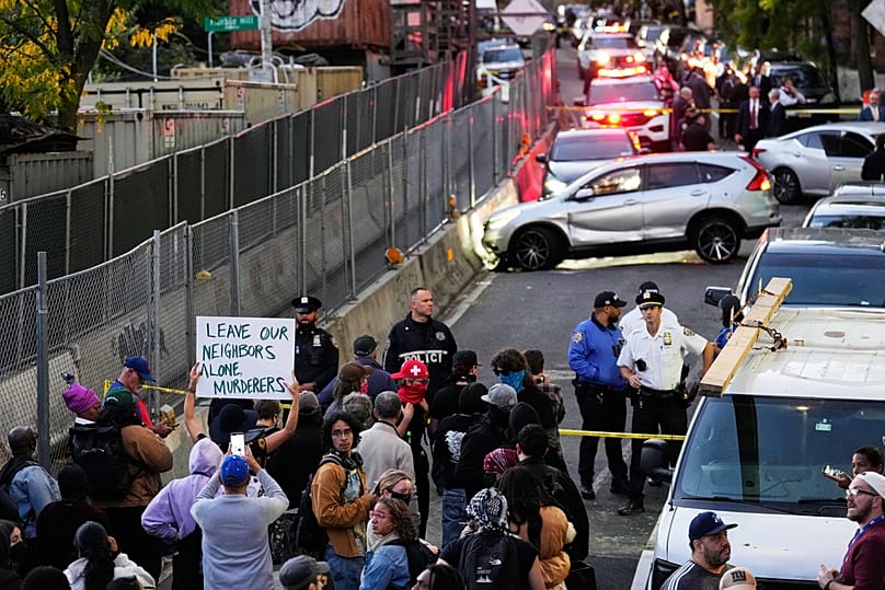 People gather at the scene of a shooting as law enforcement work the area Thursday, Oct. 8, 2026, in New York