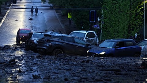 Vehicles are partially inundated in muddy floodwaters after heavy rains caused flash flooding in the Las Condes district of Santiago, Chile, Thursday, Oct. 8, 2026
