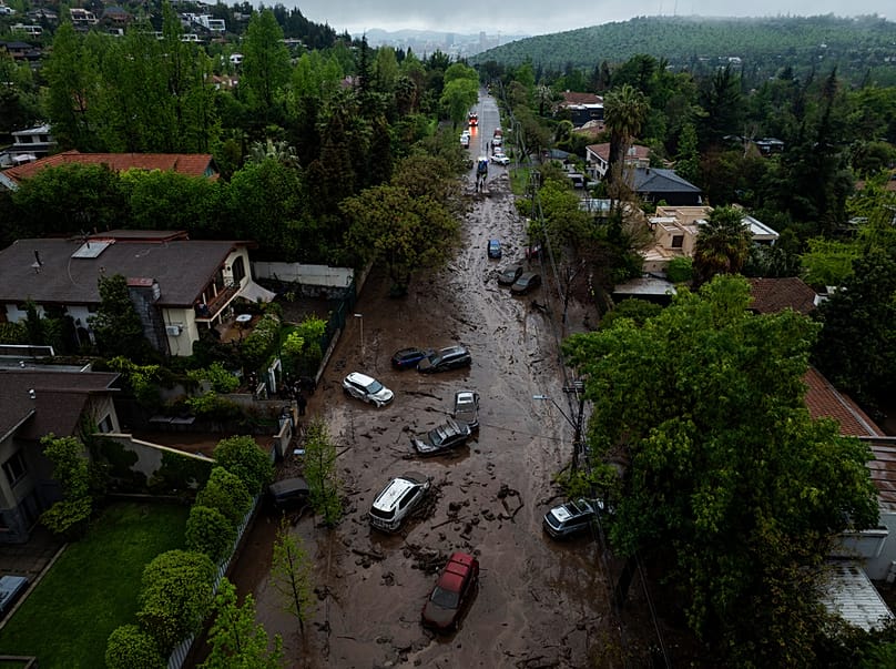 Veículos parcialmente submersos em águas lamacentas após cheias repentinas provocadas pelas chuvas intensas no bairro de Las Condes, em Santiago, Chile, quinta-feira, 8 de outubro de 2026