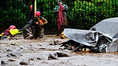 A man is pulled to safety by rescue workers after heavy rains caused flash flooding in the Las Condes district of Santiago.