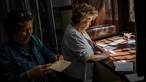 Uma mulher prepara-se para votar nas eleições legislativas de 2019, numa assembleia de voto em Madrid, a 28 de abril de 2019