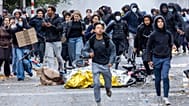 Protesters run during a national demonstration against government budget cuts and proposed reforms in Brussels.