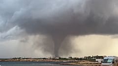 Tornado seen in the distance along the coastline