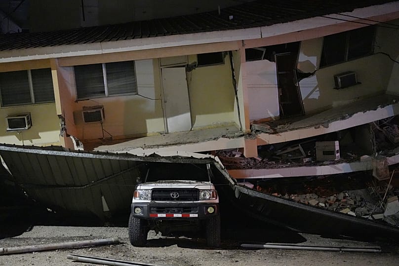 Um veículo encontra-se esmagado sob um edifício que ruiu após um terramoto ter atingido Penonome, no Panamá
