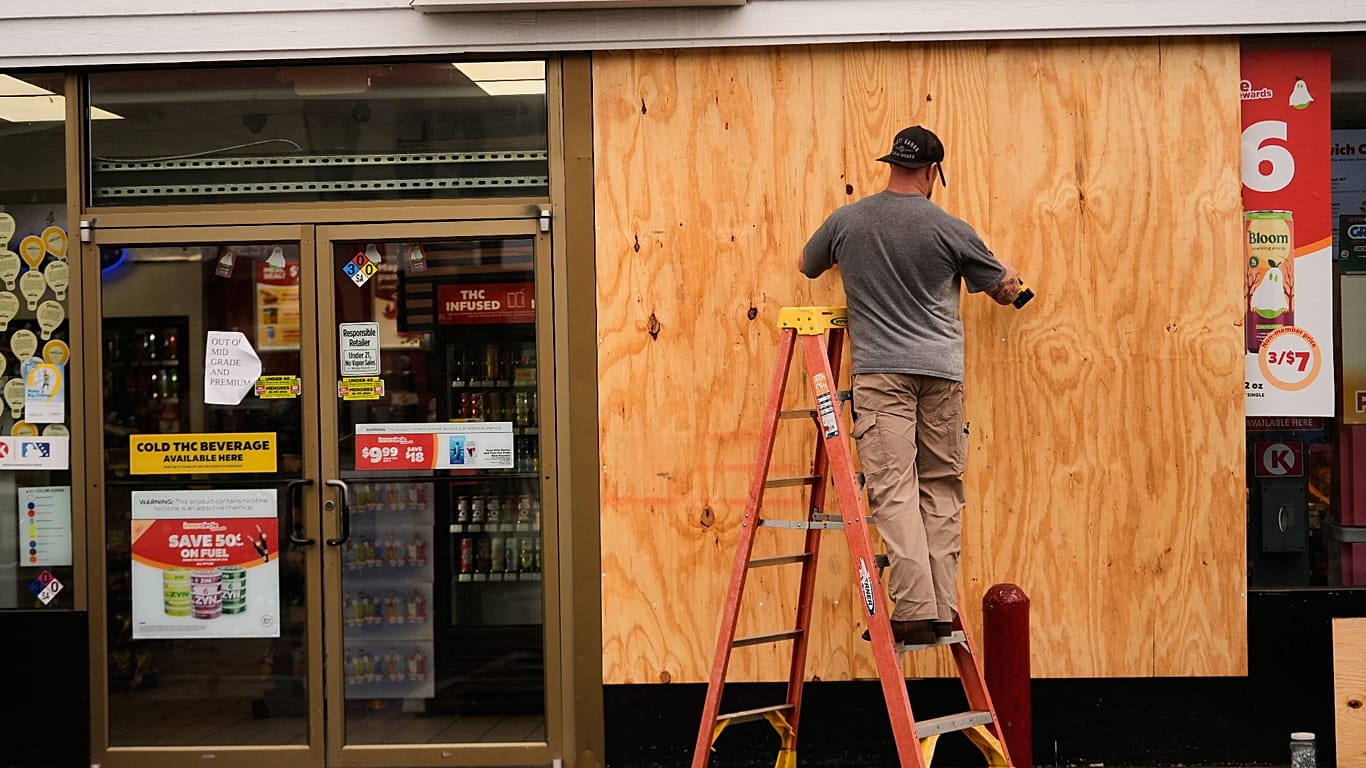 Jason Coffey boards up a convenience store at a gas station as Hurricane Isaias approaches Pensacola Beach, Fla., Friday, Oct. 9, 2026.