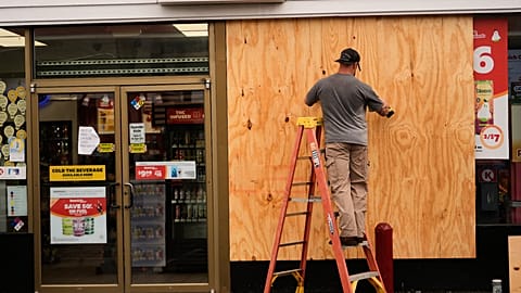 Jason Coffey boards up a convenience store at a gas station as Hurricane Isaias approaches Pensacola Beach, Fla., Friday, Oct. 9, 2026.