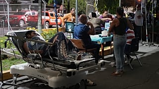Patients lie outside a hospital after being evacuated following an earthquake in Penonome