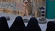 A member of Iran's Revolutionary Guard shows how to handle a Kalashnikov-style