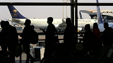 FILE - Passengers line up to check in for their flight at King Khalid Airport in Riyadh, Saudi Arabia, Monday, Jan. 11, 2021.