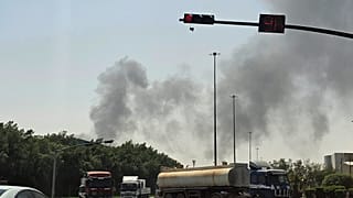 تسير المركبات على طول الطريق بينما يتصاعد الدخان الأسود من حريق في منشأة نفطية في منطقة صناعية بجنوب الرياض، المملكة العربية السعودية، السبت 3 أكتوبر 2026. (صورة AP)