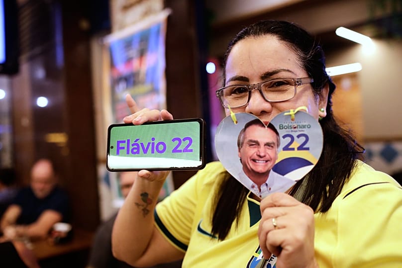 Uma apoiante do candidato presidencial da oposição, o senador Flávio Bolsonaro, posa para uma fotografia enquanto aguarda os resultados das eleições