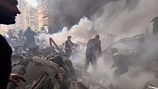 عنصر من الإطفاء يخمد حريقًا في أنقاض مبنى سكني استهدفته غارة إسرائيلية في بيروت، لبنان، الأربعاء 8 أبريل/نيسان 2026.