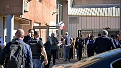 A police officer stands in front the Joseph Lakanal middle school after police detained a 14-year-old suspect in Aubagne, 12 October, 2026