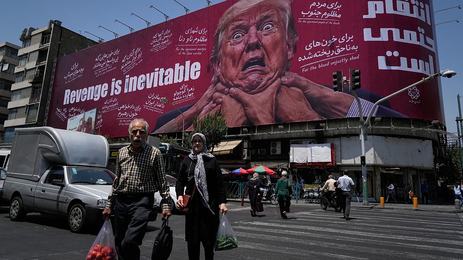 مارة يعبرون أمام لوحة إعلانية في طهران تُظهر الرئيس الأميركي دونالد ترامب ممسوكًا من رقبته، وتحمل عبارة "الانتقام حتمي" بالإنكليزية والفارسية، 27 يوليو/تموز 2026. 