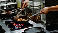 Una persona cocina en un fogón.