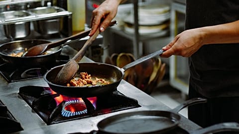 A person is cooking on a stove. 