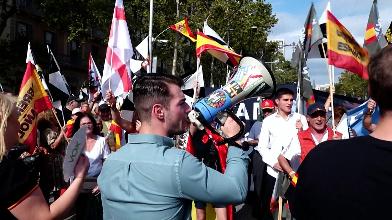 Διαδηλωτές ανεμίζουν ισπανικές σημαίες σε συγκέντρωση στη Βαρκελώνη, διαμαρτυρόμενοι για τον τρόπο που η κυβέρνηση διαχειρίζεται την προσφυγική κρίση στη Θέουτα.