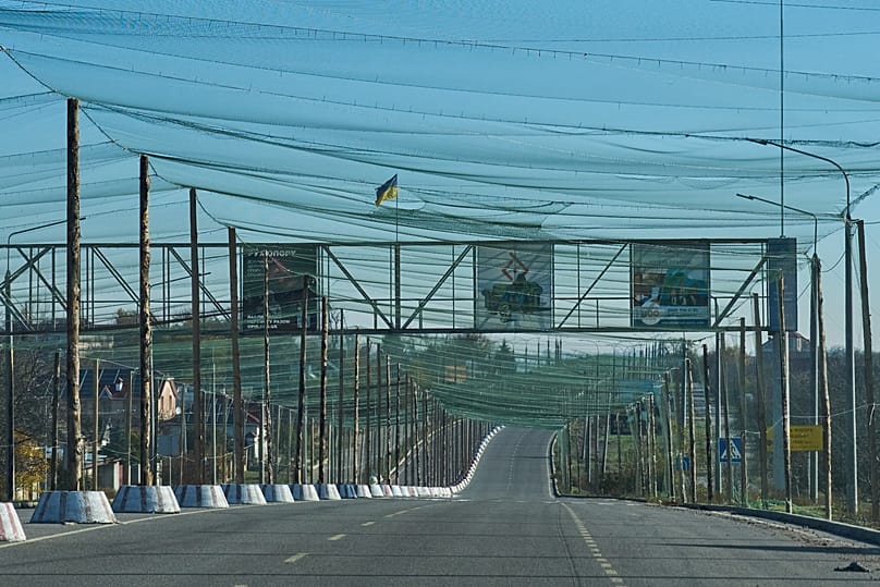 An empty road is covered with an anti-FPV-drone net at the approaches to the frontline city of Kherson, Southern Ukraine, Nov. 2, 2025. 