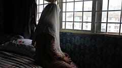 In 2023, 14-year-old child bride B. sits on a bed in a flat in Kuala Lumpur. She is expected to marry an older man.