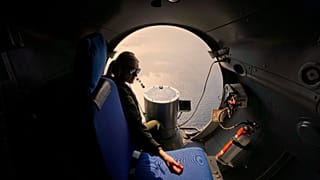A crew member of a French Navy Atlantique-2 submarine hunter naval plane during a NATO military exercise over the Black Sea, 9 April, 2025