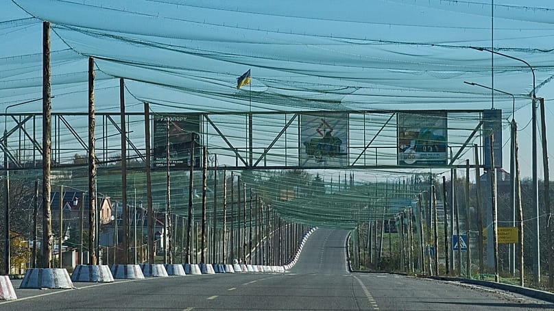 Eine leere Straße ist am Stadtrand der Frontstadt Cherson im Süden der Ukraine mit einem Netz gegen FPV-Drohnen überspannt, 2. November 2025.