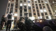 A burned car and motorcycle are seen in front of a multistory residential building damaged in a Russian drone strike in Kyiv, Ukraine, Monday, Oct. 12, 2026.