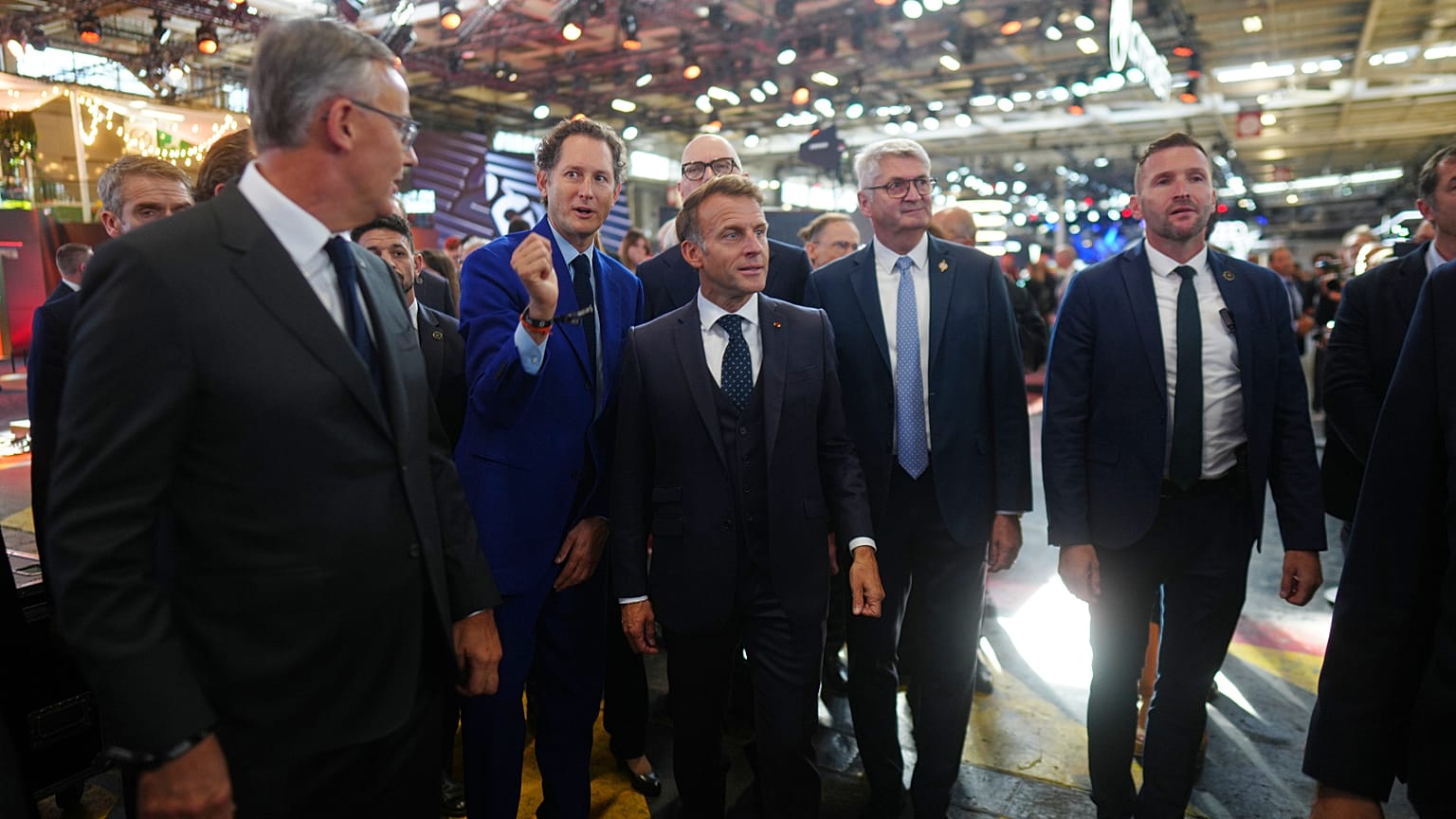 Le président français Emmanuel Macron, au centre, accompagné du président de Stellantis, John Elkann, au centre à gauche, visite le salon de l'automobile de Paris
