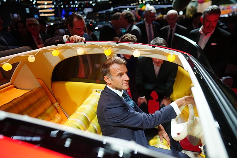 French President Emmanuel Macron sits inside Citroen 2 CV as he visits the Paris Motor Show in Paris, 12 October, 2026