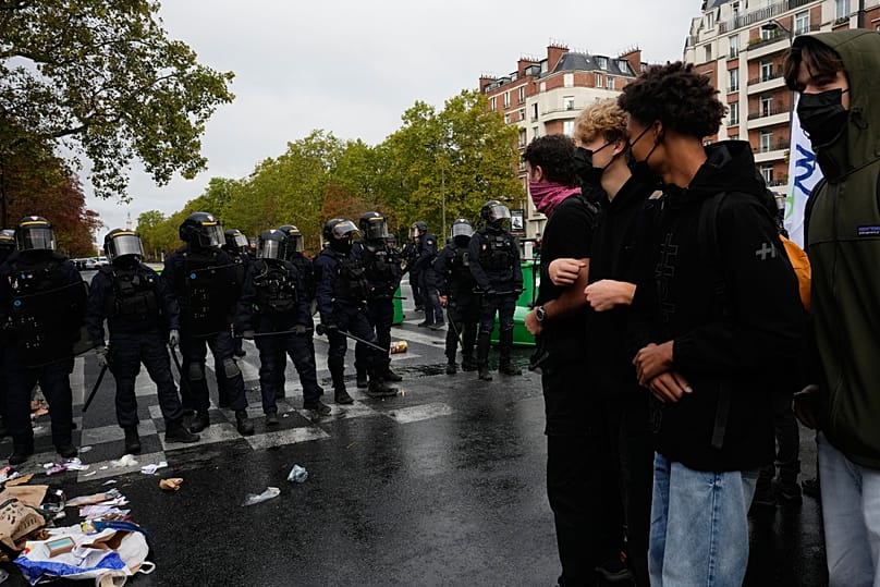 Students stand in front of a high school blockaded with garbage bins as they protest against under-resourced schools in Paris, 13 October, 2026