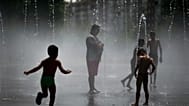 En una foto de archivo, unas personas se refrescan en una playa urbana del parque Madrid Río, en Madrid, el viernes 3 de agosto de 2018
