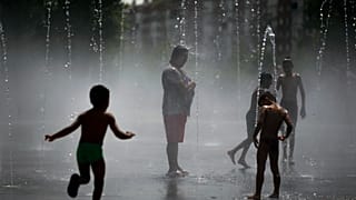 En una foto de archivo, unas personas se refrescan en una playa urbana del parque Madrid Río, en Madrid, el viernes 3 de agosto de 2018