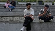 يقضي الشباب فترة ما بعد الظهر جالسين على الدرجات خارج مركز للتسوق في شمال طهران، إيران، الخميس 13 أغسطس 2026.