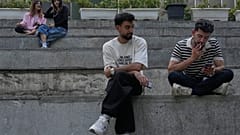 يقضي الشباب فترة ما بعد الظهر جالسين على الدرجات خارج مركز للتسوق في شمال طهران، إيران، الخميس 13 أغسطس 2026.