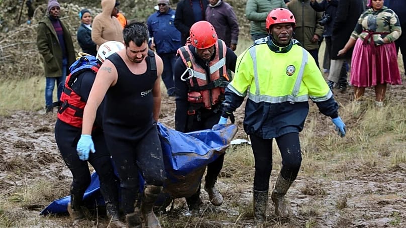 Rescue workers transport a person in a body bag during a rescue operation after floods swept through the area, in Mthatha, South Africa, Wednesday, June 11, 2025
