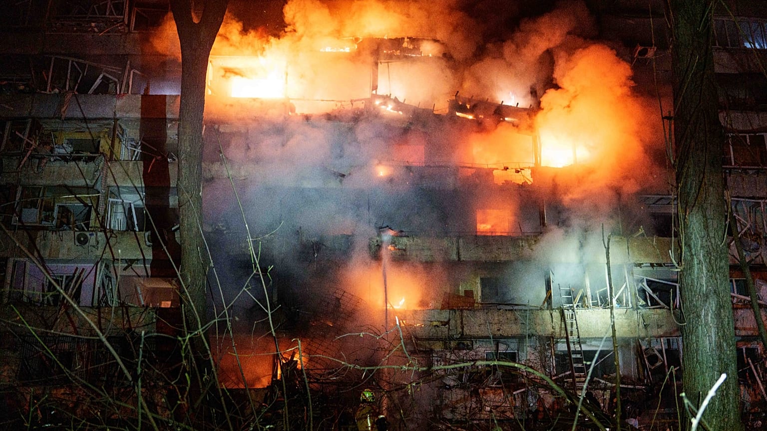 Un immeuble résidentiel de plusieurs étages, endommagé, est en feu après une frappe de missile russe sur Kyiv, le 13 octobre 2026