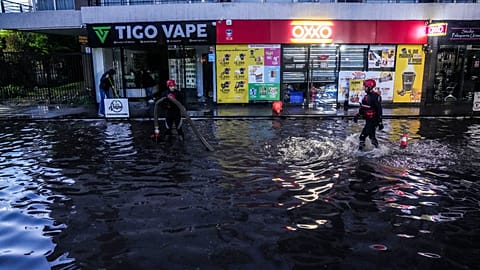 Feuerwehrleute arbeiten in einer von Regen überfluteten Tiefgarage in Santiago de Chile.