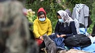 Migranci oczekują na terenie między granicami Białorusi a Polski, w pobliżu wsi Usnarz Górny, w piątek 20 sierpnia 2021 roku
