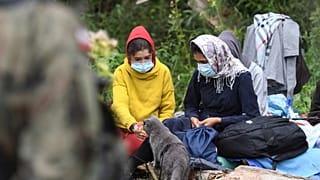 Migranci oczekują na terenie między granicami Białorusi a Polski, w pobliżu wsi Usnarz Górny, w piątek 20 sierpnia 2021 roku