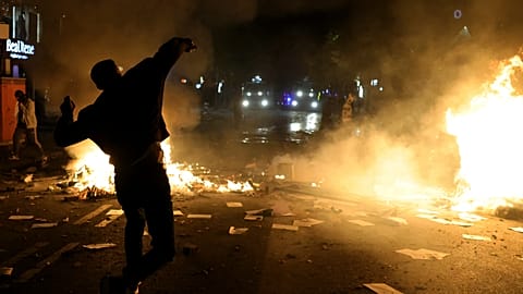 Ein Demonstrant wirft am Dienstag in Tirana, Albanien, einen Stein auf Polizisten.