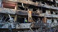 Сотрудник муниципальной службы осматривает поврежденный жилой дом после ночного ракетного обстрела Киева (Украина) со стороны России в среду, 14 октября 2026 года.