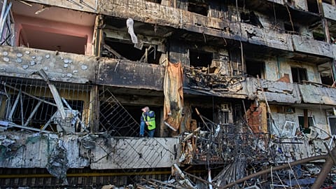A municipal worker examines a damaged apartment building after Russia's night missile attack in Kyiv, Ukraine, Wednesday, 14 Oct., 2026.