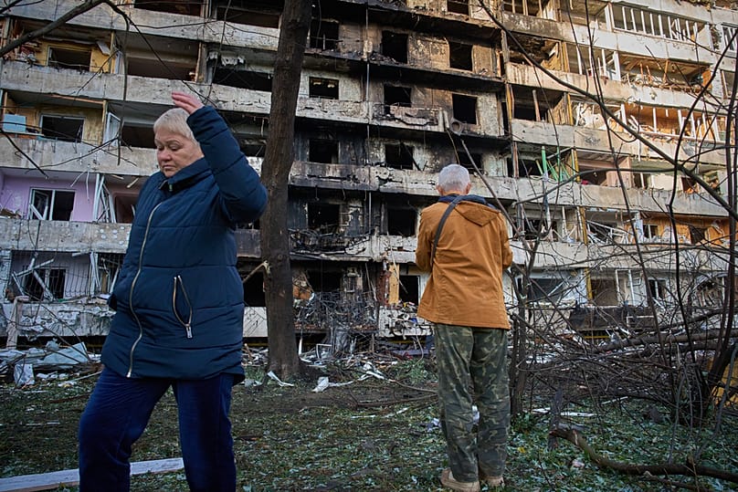 Жители реагируют, покидая свои поврежденные дома после ночного ракетного обстрела, совершенного Россией в Киеве, Украина, в среду, 14 октября 2026 года. 
