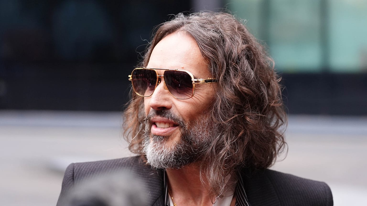 Russell Brand fala aos jornalistas à chegada ao Tribunal da Coroa de Southwark, em Londres, em 14 de outubro de 2026