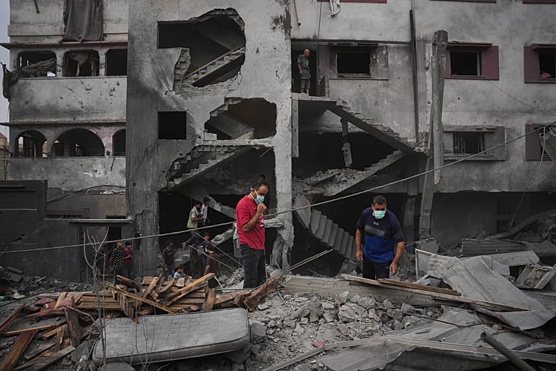 فلسطينيون يتفقدون مبنى دمّرته غارة إسرائيلية في الزوايدة وسط قطاع غزة، 11 أكتوبر 2026.