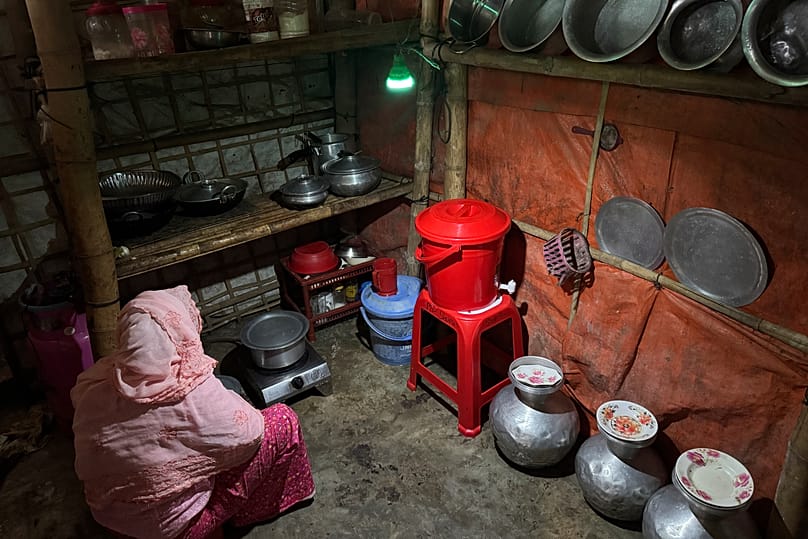 Auf dieser mit einem Handy aufgenommenen Aufnahme nutzt eine Frau eine von Solarmodulen gespeiste Lampe in ihrer Küche, am vierten Oktober 2026 in Teknaf, Bangladesch. 