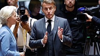 French President Emmanuel Macron, center, speaks with European Commission President Ursula von der Leyen during a round table meeting at the EU summit in Brussels, 15 October.